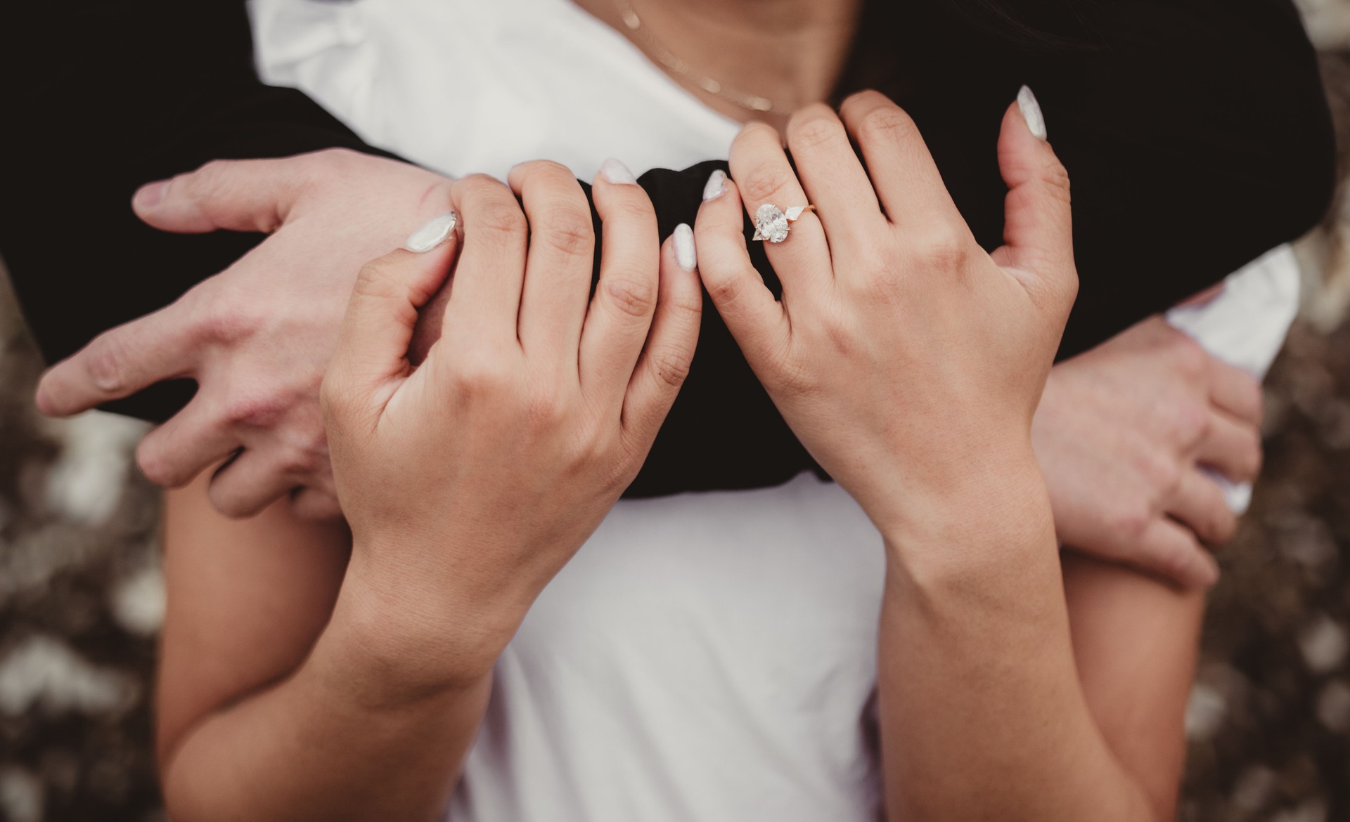 Bride and groom with engagement ring close up