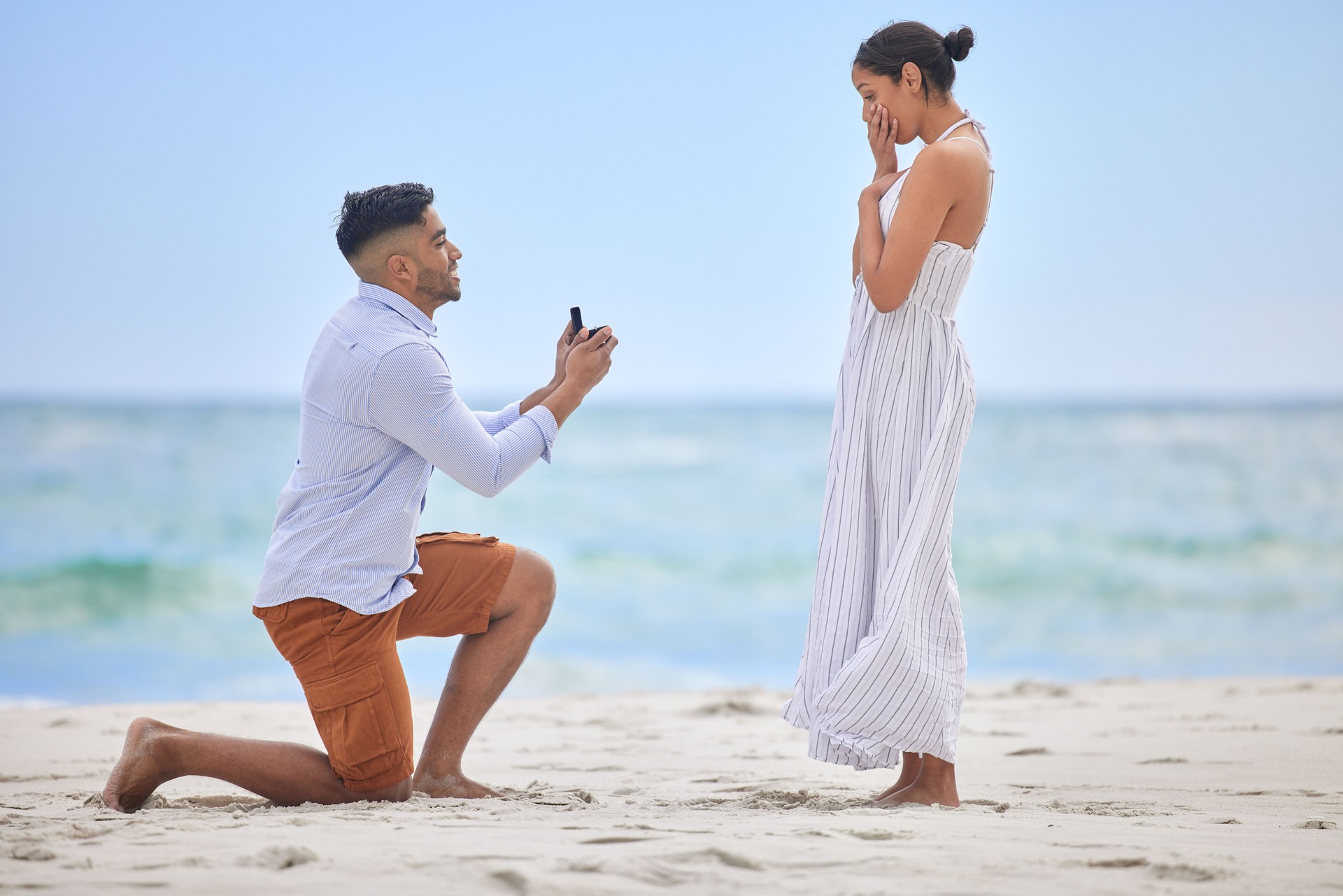 Shot of a young man proposing to his girlfriend on the beach