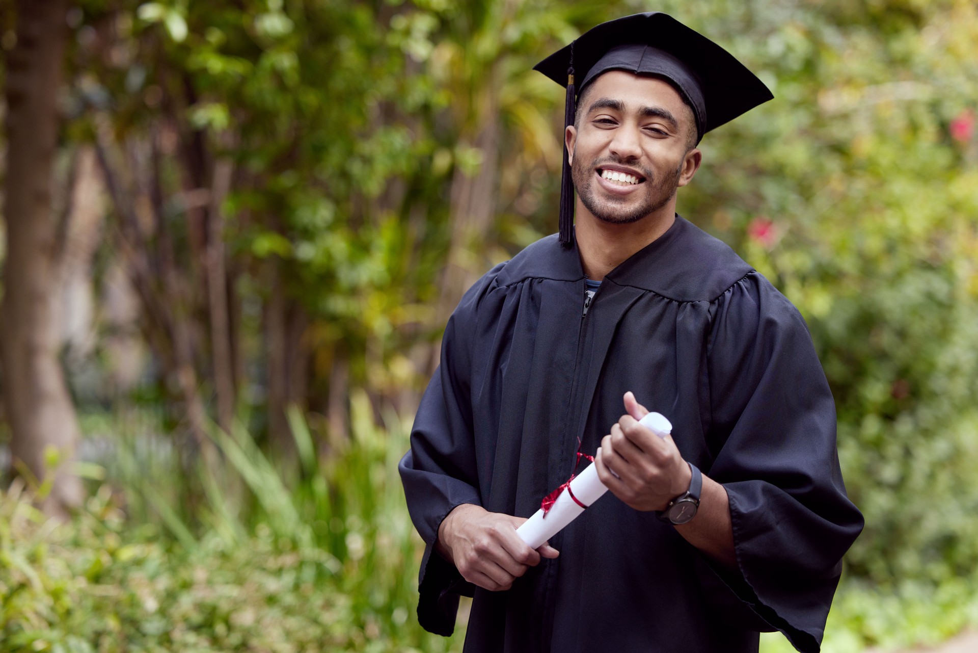 Shot of a young man holding a certificate on graduation day